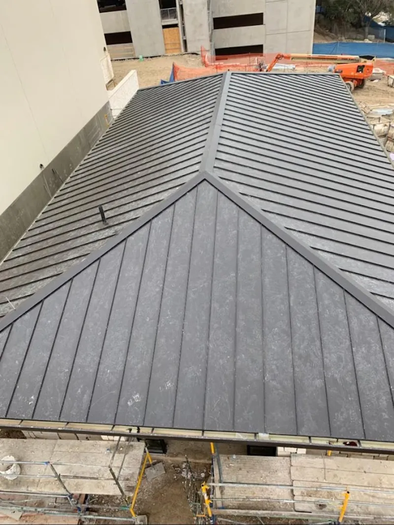 Commercial metal roof construction with crane equipment in Fruitport